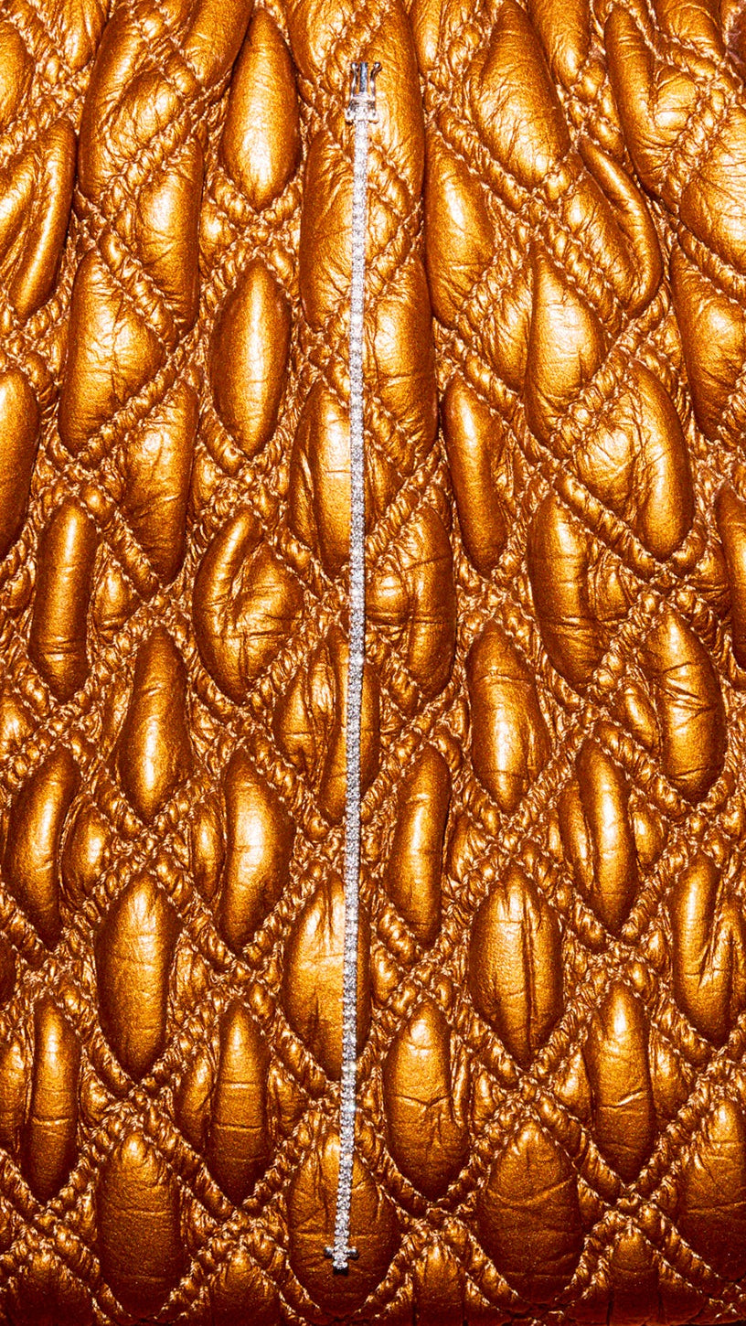 Close-up of a textured brown fabric with a zipper running vertically through it.
